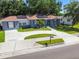 Beautiful one-story house with a long driveway, lush lawn, solar panels, and vibrant landscaping at 6207 Gulfport S Blvd, Gulfport, FL 33707