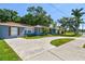 Charming exterior view of a light blue home with a circular driveway and lush landscaping at 6207 Gulfport S Blvd, Gulfport, FL 33707