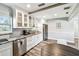Bright kitchen featuring white cabinets, granite countertops, and stainless steel appliances at 6207 Gulfport S Blvd, Gulfport, FL 33707