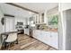 Modern kitchen with white cabinets, stainless steel appliances, granite countertops, and wood flooring at 6207 Gulfport S Blvd, Gulfport, FL 33707