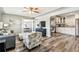 Bright living room with hardwood flooring, modern furniture, ceiling fan, and views into dining and kitchen at 6207 Gulfport S Blvd, Gulfport, FL 33707