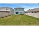 Large, fenced in back yard with a swing set and patio seating area outside the rear sliding glass door at 6648 Seaway Dr, Brooksville, FL 34604