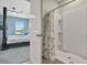 Attached bath featuring a glass enclosed shower and views into the Primary bedroom with its four-poster bed and ceiling fan at 6648 Seaway Dr, Brooksville, FL 34604