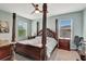 Spacious main bedroom features a four poster bed, ceiling fan, and sunny windows with a bedside table on each side at 6648 Seaway Dr, Brooksville, FL 34604