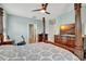 Main bedroom featuring a four-poster bed, TV, ceiling fan, and adjoining door to a hallway and connected bath at 6648 Seaway Dr, Brooksville, FL 34604