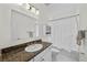 Clean bathroom with decorative mirror and vanity with granite countertop, and shower with curtain at 6922 Duffy Ln, Tampa, FL 33616