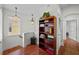 Well-lit hallway with hardwood floors, decorative lighting, and easy access to other rooms at 6922 Duffy Ln, Tampa, FL 33616