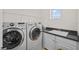 Bright laundry room featuring modern washer and dryer, granite countertops, and ample cabinet space at 6922 Duffy Ln, Tampa, FL 33616