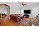 Spacious living room featuring a large leather sectional, hardwood floors, and a brick archway at 6922 Duffy Ln, Tampa, FL 33616