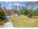 Expansive backyard featuring a pool, outdoor grill area, mature trees, and a shed at 6938 Coronet Dr, New Port Richey, FL 34655