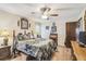 Cozy bedroom with floral bedding, wood accents, and a ceiling fan with light fixture at 6938 Coronet Dr, New Port Richey, FL 34655