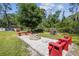 Outdoor fire pit area with stone firepit, benches, and wood storage at 6938 Coronet Dr, New Port Richey, FL 34655