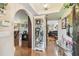 Spacious foyer with hardwood floors, decorative display cabinet, and archway leading into the living area at 6938 Coronet Dr, New Port Richey, FL 34655
