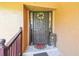 Elegant front door with a floral wreath, decorative sidelights, and a 'Home Sweet Home' welcome mat at 6938 Coronet Dr, New Port Richey, FL 34655