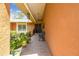 Inviting front porch featuring tiled flooring, a seating bench, and vibrant potted plants at 6938 Coronet Dr, New Port Richey, FL 34655