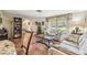 Bright living room with patterned sofas, colorful rug, and large window providing natural light at 6938 Coronet Dr, New Port Richey, FL 34655