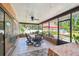 Enclosed patio featuring a dining table, fan, and a screened-in area overlooking the pool and backyard at 6938 Coronet Dr, New Port Richey, FL 34655