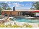 Backyard pool area featuring a waterfall feature and access to a screened in patio at 6938 Coronet Dr, New Port Richey, FL 34655
