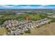 Expansive aerial view of a neighborhood with houses, trees, and open fields, featuring a home marked with a location pin at 7207 Peregrina Loop, Wesley Chapel, FL 33545