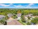 Scenic aerial view of a home nestled in a lush, green neighborhood with mature trees and blue skies at 7207 Peregrina Loop, Wesley Chapel, FL 33545