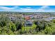 Panoramic aerial view of a house with a screened-in pool, surrounded by lush greenery and other homes at 7207 Peregrina Loop, Wesley Chapel, FL 33545