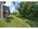 Expansive lawn of the property with mature trees and the side of the screened in pool at 7207 Peregrina Loop, Wesley Chapel, FL 33545
