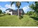 Well-maintained backyard with lush lawn, mature trees, and a view of the screened-in pool area at 7207 Peregrina Loop, Wesley Chapel, FL 33545