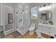 Modern bathroom features a glass-enclosed shower, updated vanity with wood accents and a sleek round mirror at 7207 Peregrina Loop, Wesley Chapel, FL 33545