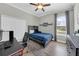 Cozy bedroom with light-colored walls, wooden bedframe, and a gray rug, complemented by natural light at 7207 Peregrina Loop, Wesley Chapel, FL 33545