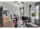Bright exercise room with wood floors, offering natural light from dual windows overlooking outdoor area and pool at 7207 Peregrina Loop, Wesley Chapel, FL 33545