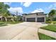 A modern home with a three-car garage, and landscaped yard on a sunny day at 7207 Peregrina Loop, Wesley Chapel, FL 33545