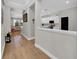 Hallway with view of modern kitchen featuring white cabinets and light-filled living room at 7207 Peregrina Loop, Wesley Chapel, FL 33545