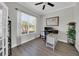 Home office featuring an adjustable-height desk, wood-look floors and a large window at 7207 Peregrina Loop, Wesley Chapel, FL 33545