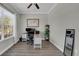 Bright home office featuring wood-look floors, a large window and an adjustable-height desk at 7207 Peregrina Loop, Wesley Chapel, FL 33545