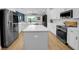 Bright kitchen boasts stainless steel appliances, white cabinets, and spacious center island at 7207 Peregrina Loop, Wesley Chapel, FL 33545