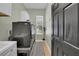 Laundry room featuring updated appliances and a modern dark-toned door at 7207 Peregrina Loop, Wesley Chapel, FL 33545
