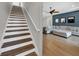 The house has a staircase and a living room featuring a large sectional sofa and a blue accent wall at 7207 Peregrina Loop, Wesley Chapel, FL 33545