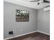 Bedroom with a window and ceiling fan, grey walls, and dark laminate floors at 740 Crystal Dr, Palm Harbor, FL 34683