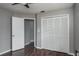 Bedroom with a bi-fold closet, grey walls, dark floors, and an open doorway to another room at 740 Crystal Dr, Palm Harbor, FL 34683