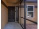 View of a front door and window from the screened-in porch with brick flooring at 740 Crystal Dr, Palm Harbor, FL 34683