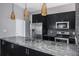 Modern kitchen features stainless steel appliances, granite countertops and decorative lighting at 740 Crystal Dr, Palm Harbor, FL 34683
