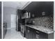 Kitchen with stainless steel appliances, dark cabinets and mosaic tile backsplash at 740 Crystal Dr, Palm Harbor, FL 34683