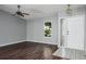 Living room featuring dark wood floors, grey walls, a ceiling fan, and a bright window at 740 Crystal Dr, Palm Harbor, FL 34683