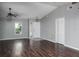 Spacious living room with wood flooring, a ceiling fan, and a bright front door at 740 Crystal Dr, Palm Harbor, FL 34683