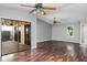 This spacious living room features wood flooring, a ceiling fan, and sliding glass doors leading to an outdoor patio at 740 Crystal Dr, Palm Harbor, FL 34683