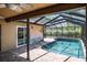Sparkling pool within a screened enclosure, surrounded by lush landscaping and decorative mural on the house at 740 Crystal Dr, Palm Harbor, FL 34683