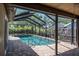 The screened-in pool area features a well-maintained pool, brick pavers, and lush landscaping for privacy at 740 Crystal Dr, Palm Harbor, FL 34683