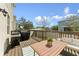 Outdoor wooden deck area with comfortable seating, table, and grill at 7509 S Sherrill St, Tampa, FL 33616