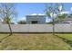 Large, grassy backyard enclosed by a white fence provides privacy at 7509 S Sherrill St, Tampa, FL 33616
