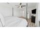 Spacious bedroom features a four-post bed, ceiling fan, television, and modern decor at 7509 S Sherrill St, Tampa, FL 33616